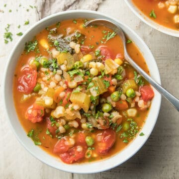 Bowl of Vegetable Barley Soup with spoon.