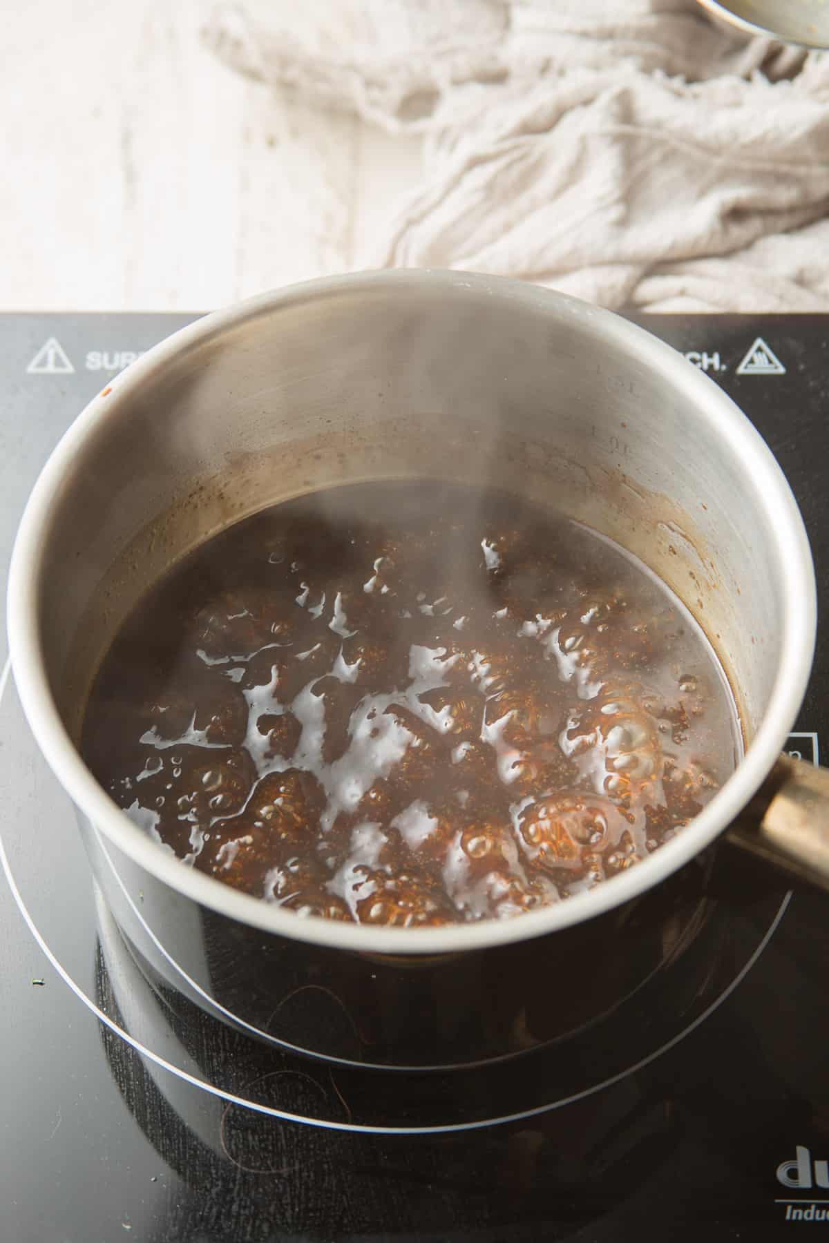 Cocine a fuego lento la salsa de sésamo en una cacerola.
