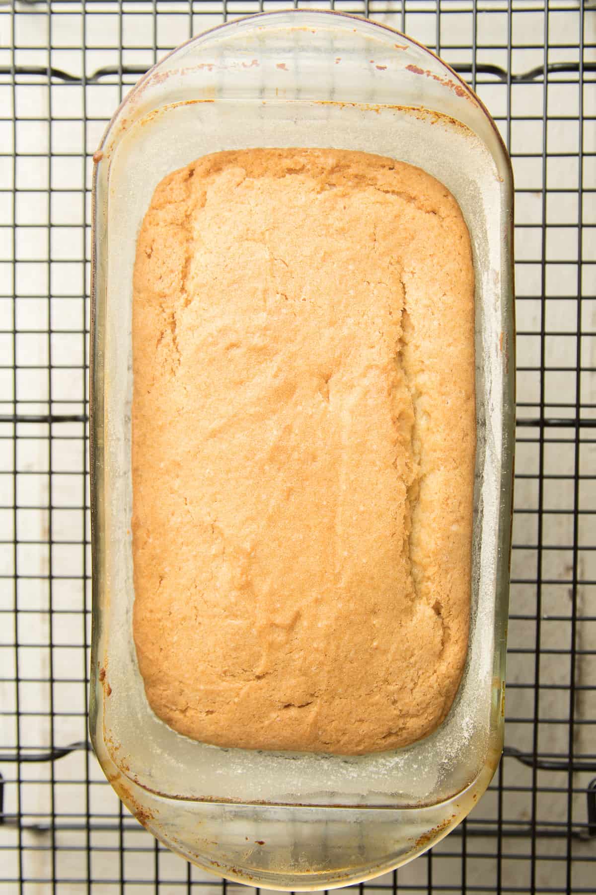 Vegan Pound Cake in a loaf pan on a cooling rack.