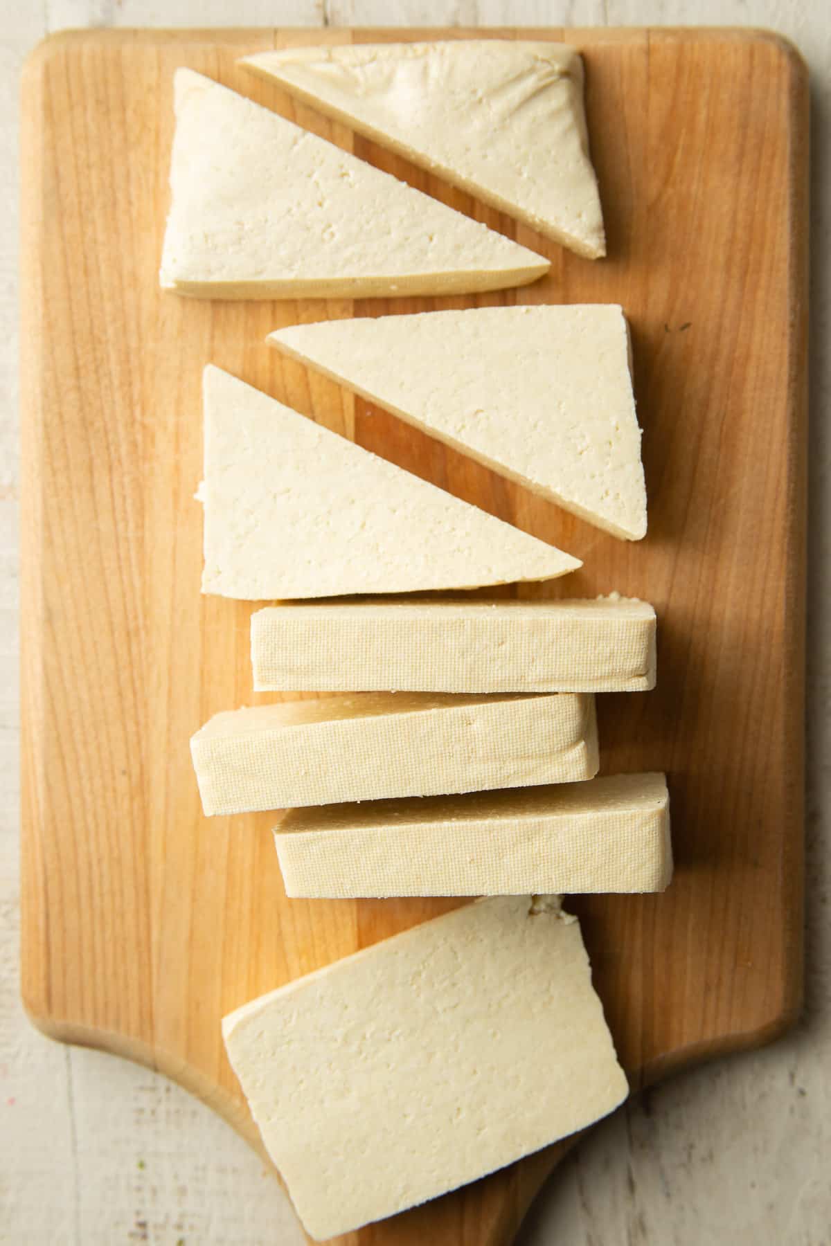 Sliced block of tofu on a cutting board.