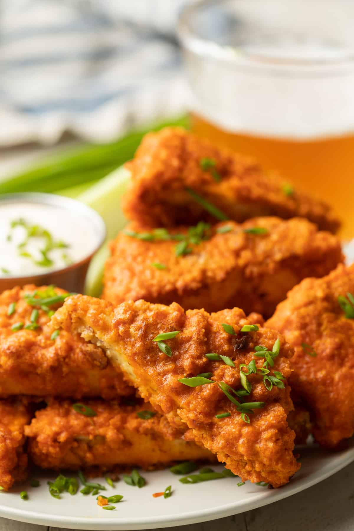 Close up of Buffalo Tofu Wings on a plate with dish of dressing.