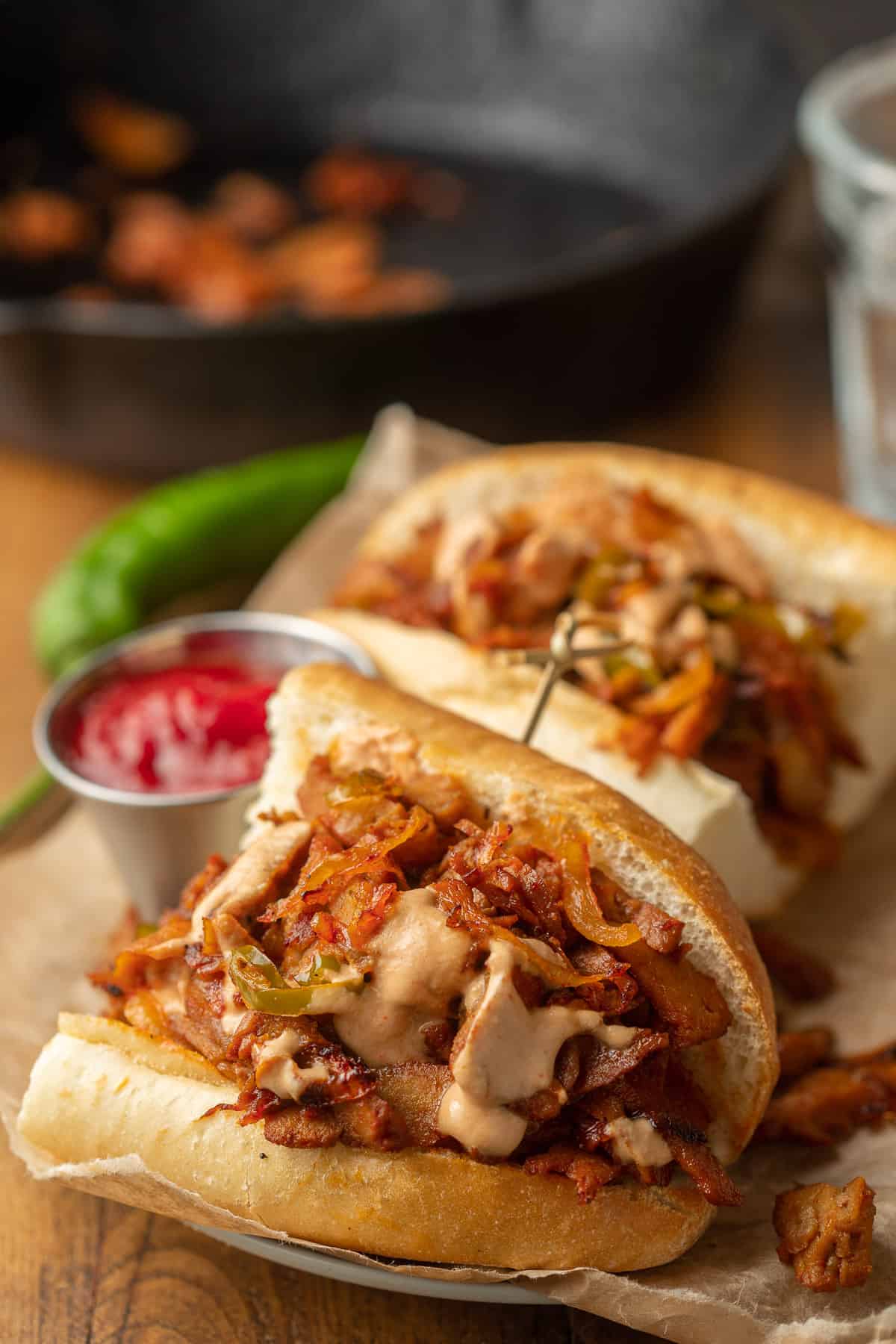 Vegan Philly Cheesesteak Sandwich with skillet in the background.