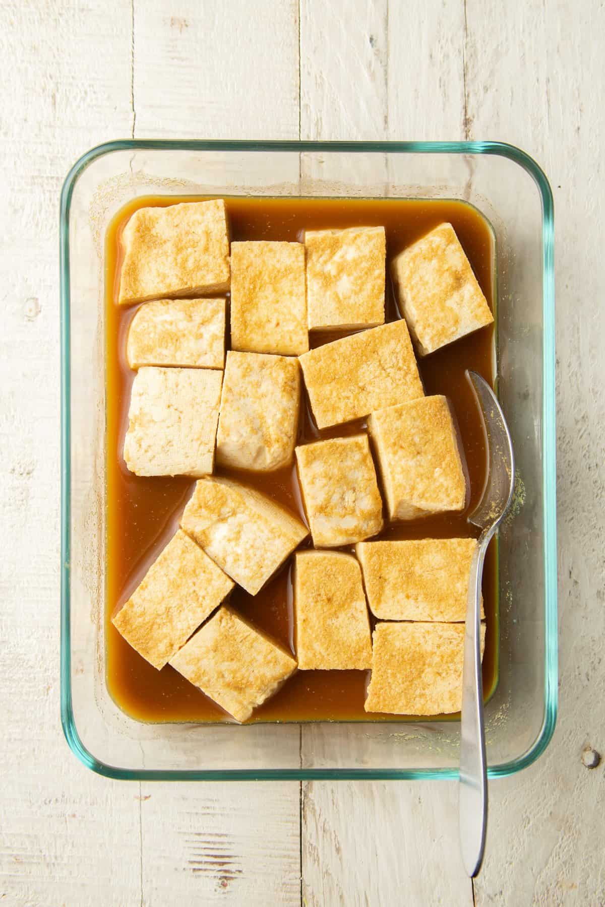 Tofu pieces in a dish marinating.