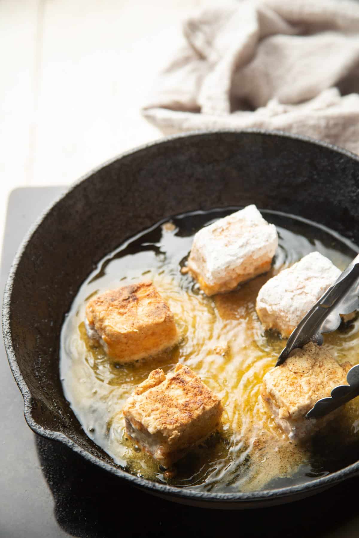 Tofu Chicken nuggets frying in a skillet.