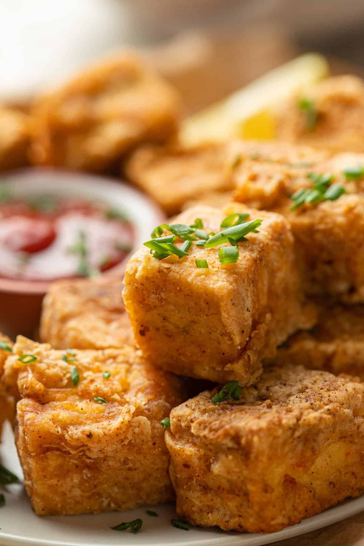 Close up of Tofu Chicken Nuggets on a plate with fresh chives on top.