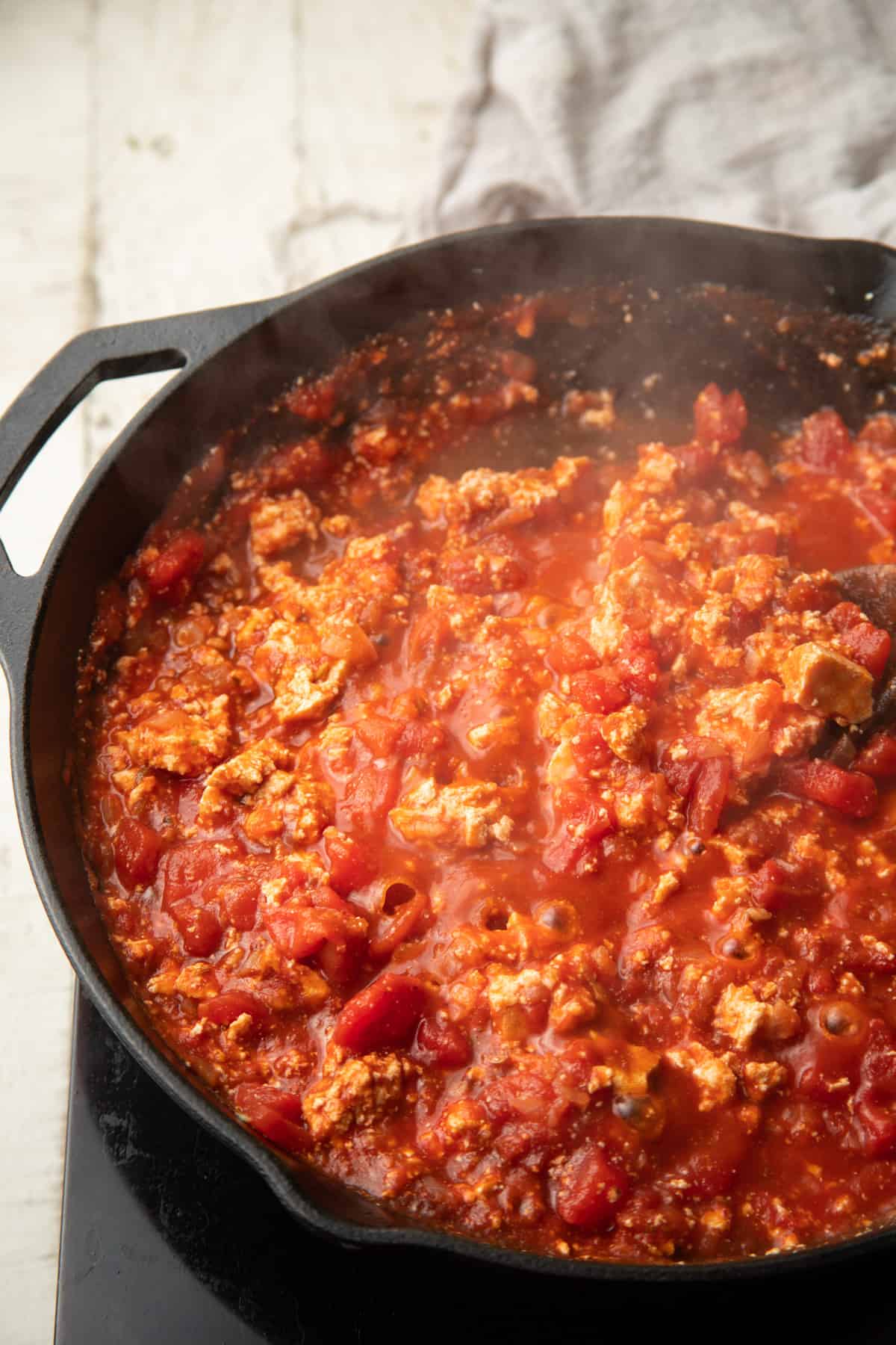 Tofu and tomato sauce simmering in a skillet.