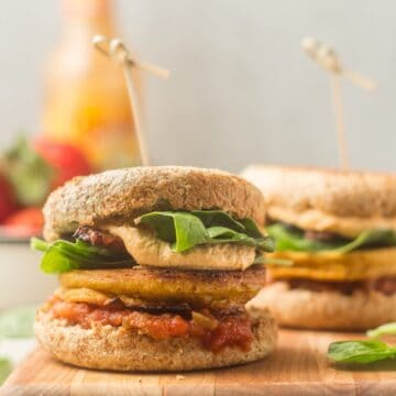 Two Vegan Breakfast Sandwiches on a cutting board.