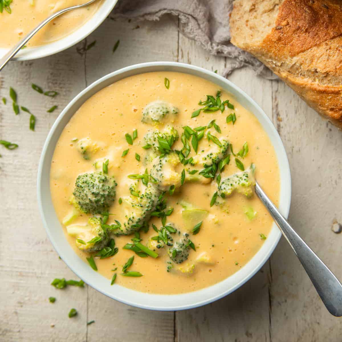 Tazón de sopa vegana de brócoli y queso cheddar con cuchara