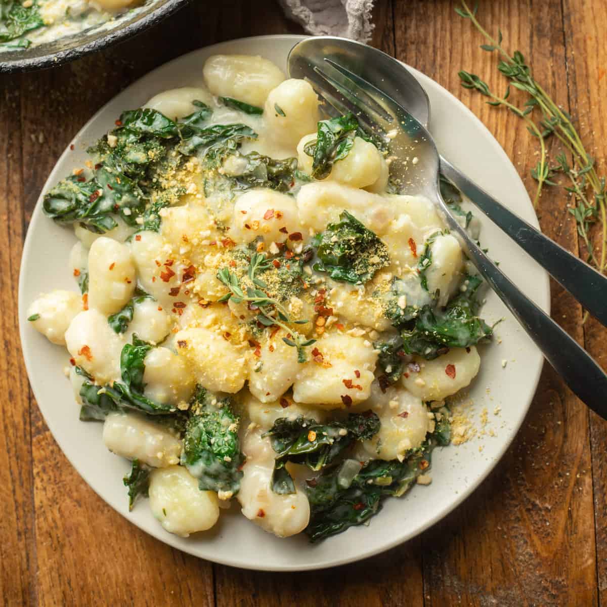 Plate of Vegan Gnocchi with Creamy Lemon Garlic Sauce with fork and spoon.