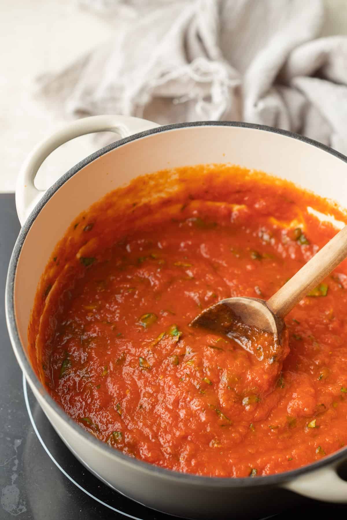 Olla de salsa de tomate hirviendo a fuego lento en una estufa.