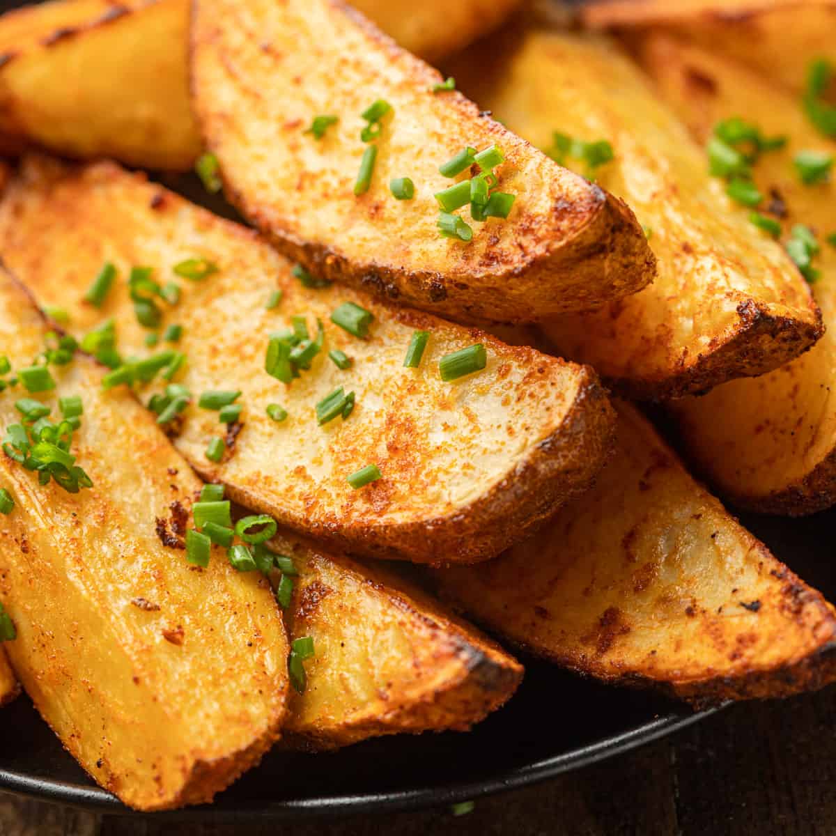 Close Up of Air Fryer Potato Wedges topped with fresh chives.