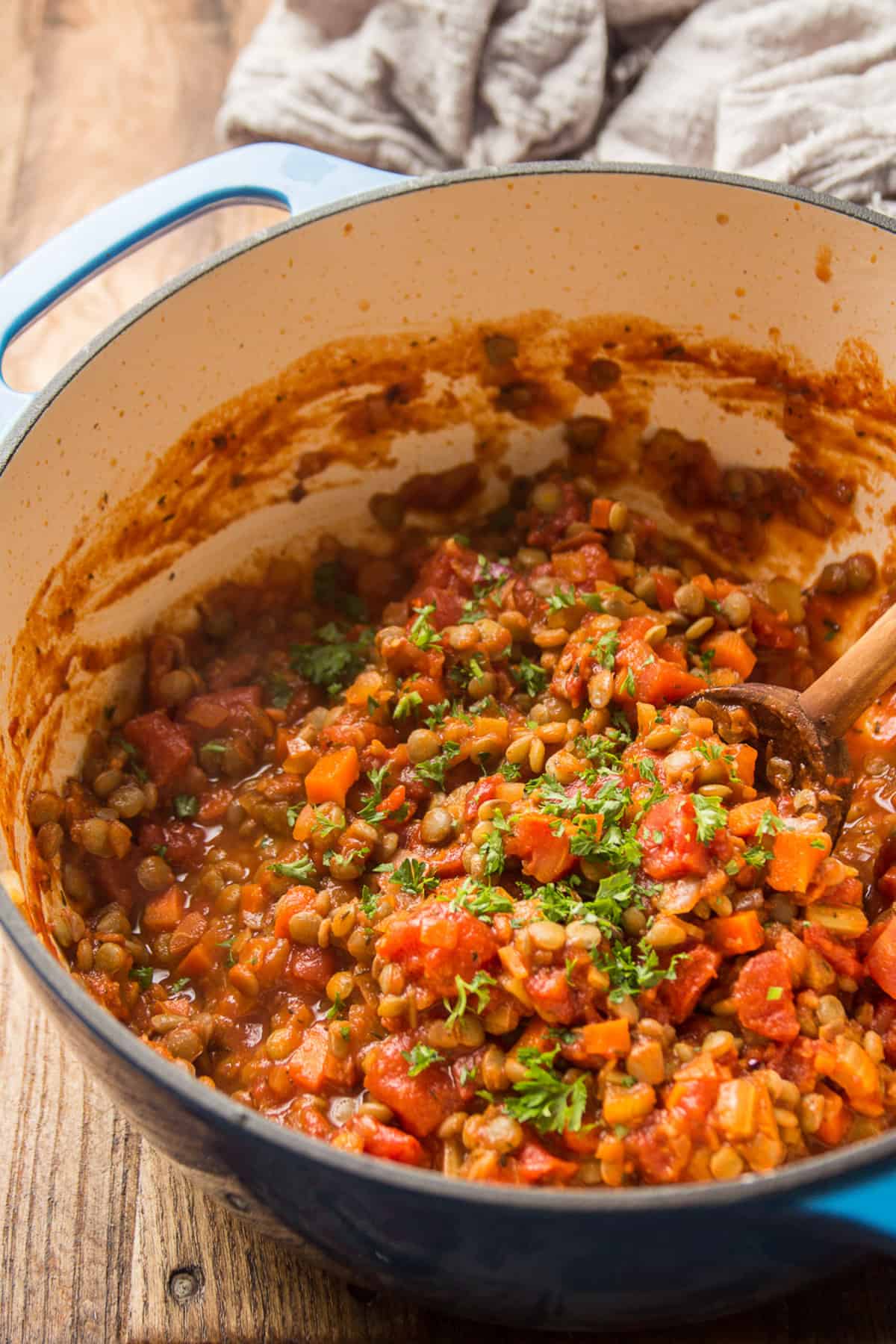 Pot of Lentil Bolognese with a wooden spoon.