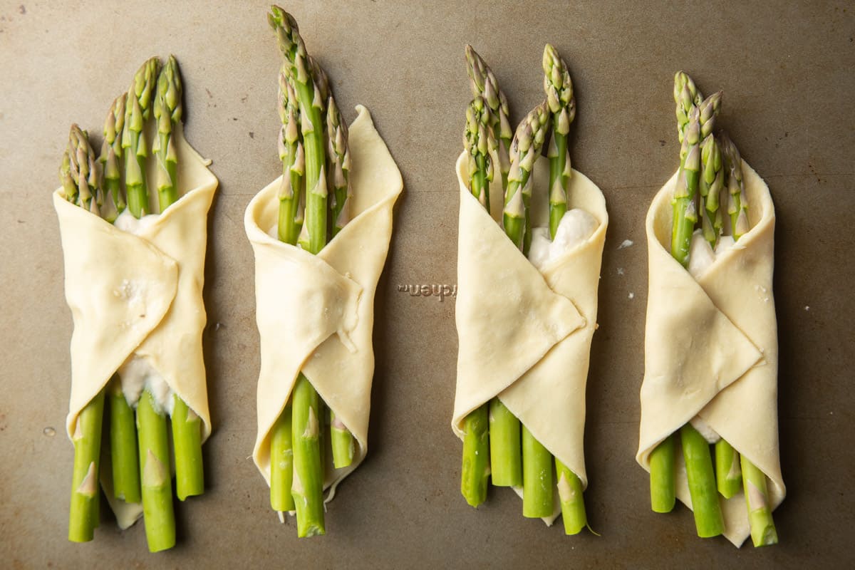 Unbaked Puff Pastry Wrapped Asparagus on a baking sheet.
