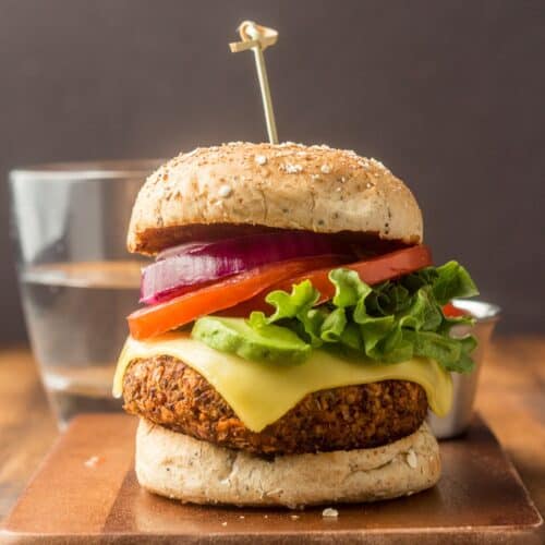 Quinoa burger topped with lettuce, tomato, vegan cheese, onions and avocado.