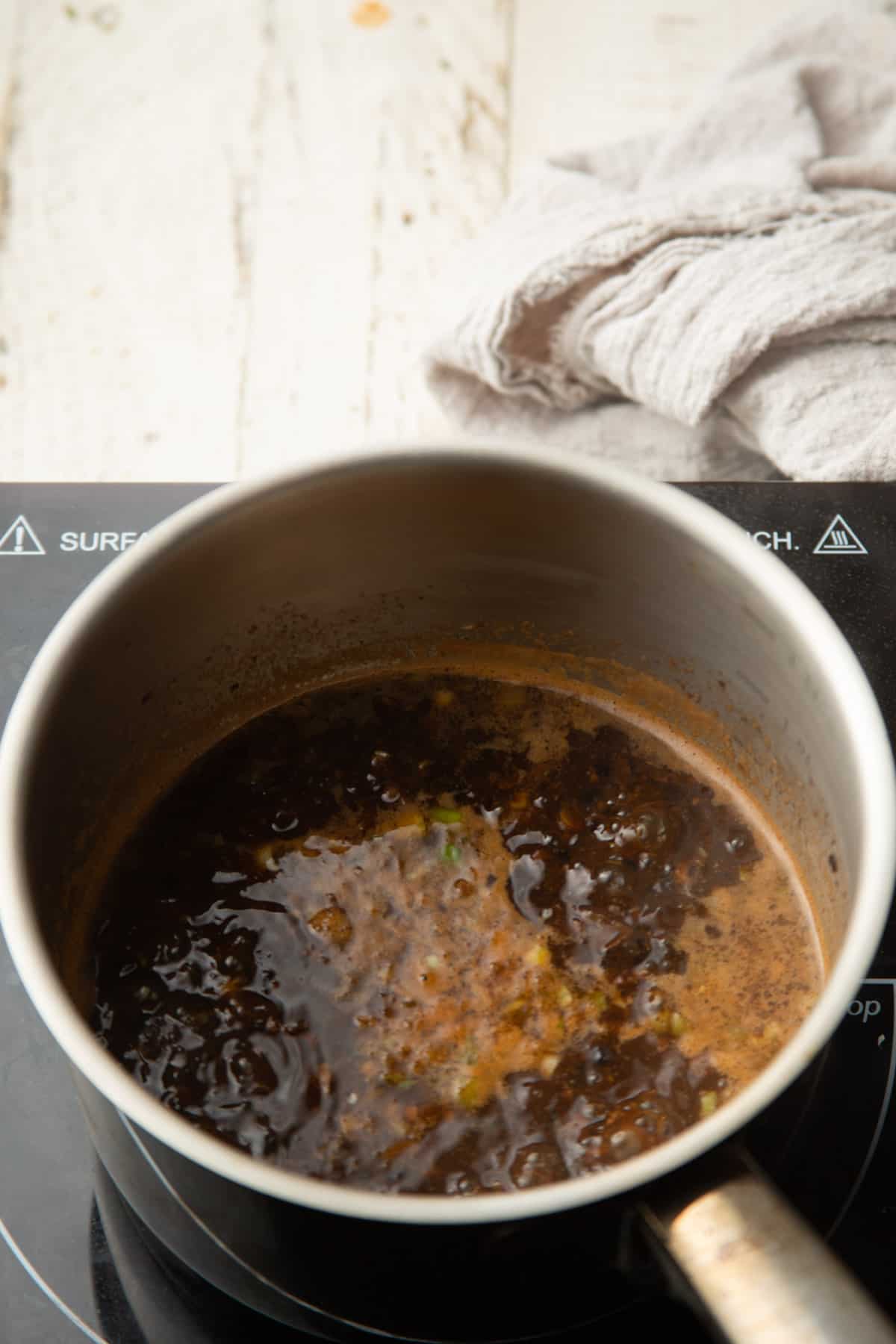 Black bean sauce simmering in a saucepan.