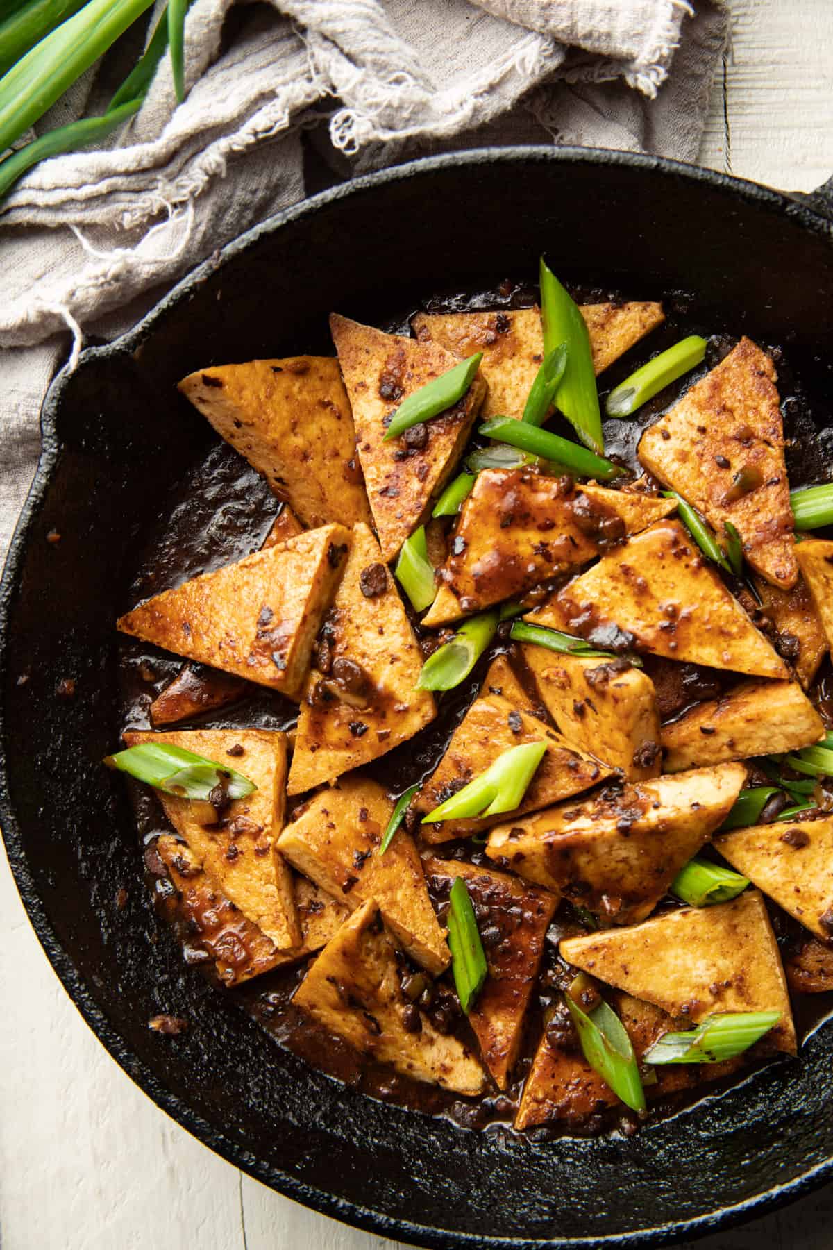 Skillet filled with Tofu with Chinese Black Bean Sauce and scallions.