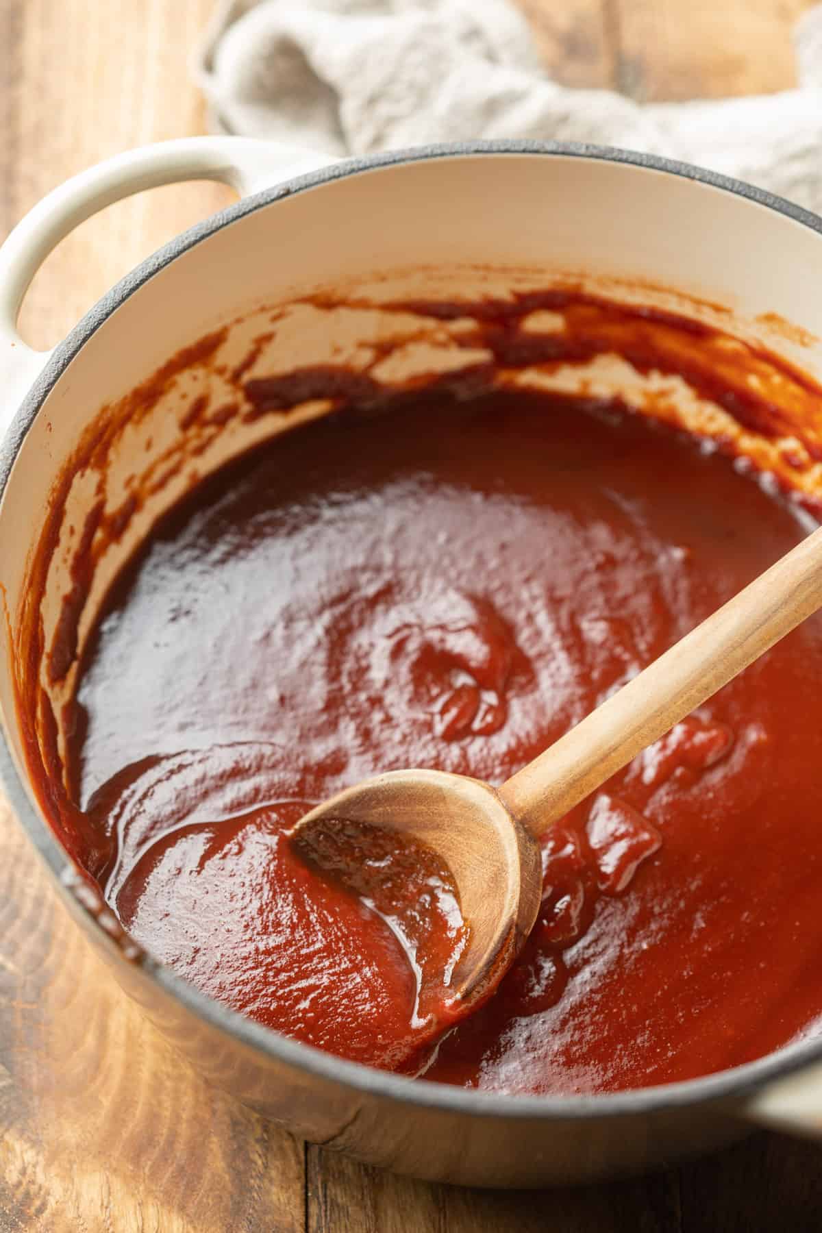 Pot of Vegan BBQ Sauce with a wooden spoon.