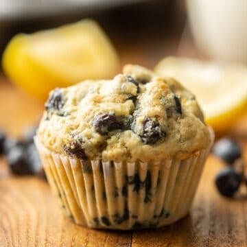 Vegan Blueberry Muffin with lemon slices and blueberries in the background.