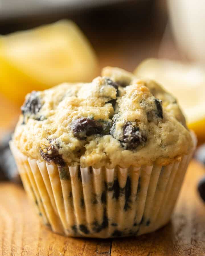 Vegan Blueberry Muffin with lemon slices and blueberries in the background.