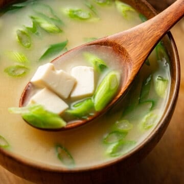 Close up of a spoonful of Vegan Miso Soup being lifted from a bowl.