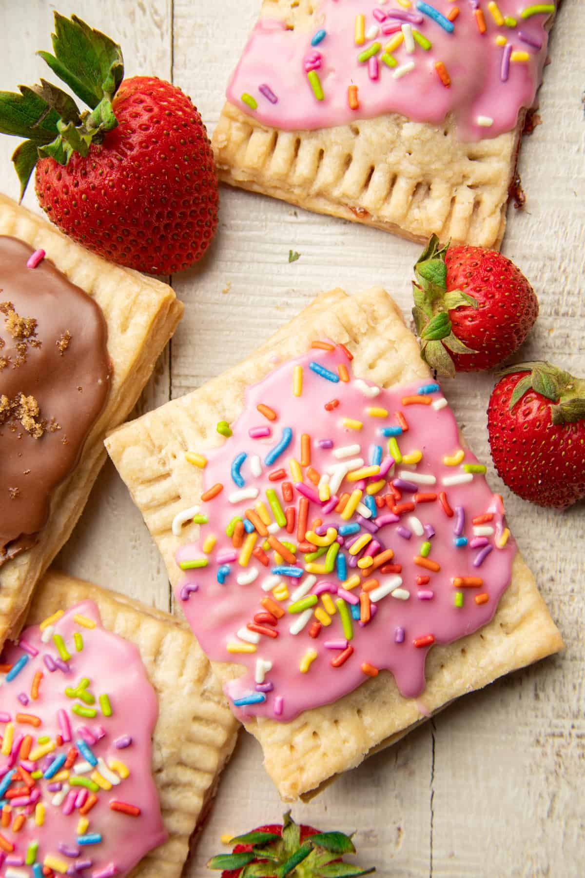 Wooden surface set with Vegan Pop Tarts and strawberries.