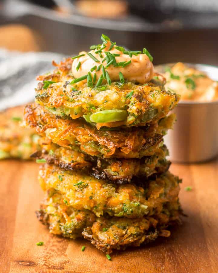 Stack of Vegetable Fritters with dish of chipotle mayo and skillet in the background.