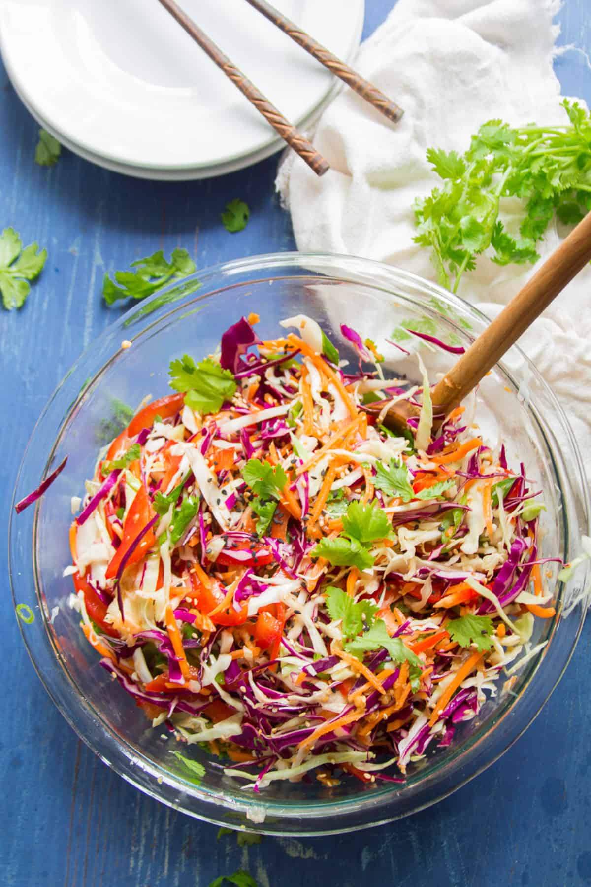 Bowl of Asian Slaw with a wooden spoon in it.