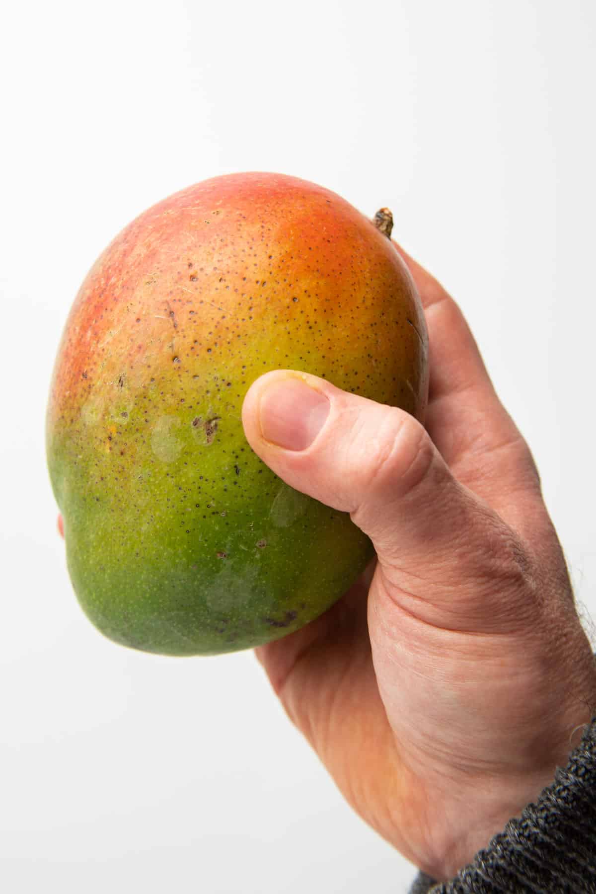 Hand squeezing a mango.