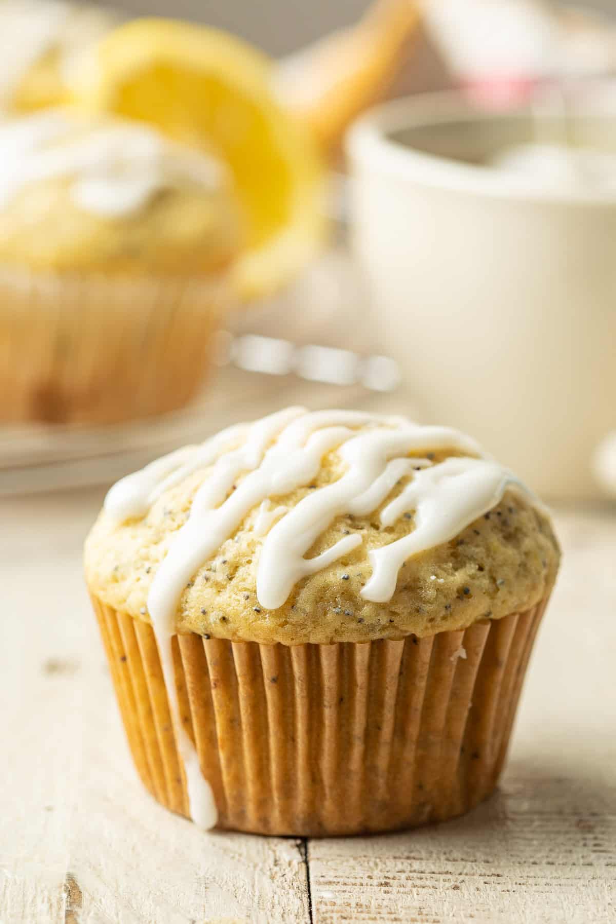 Vegan Lemon Poppy Seed Muffin with tea cup and lemons in the background.
