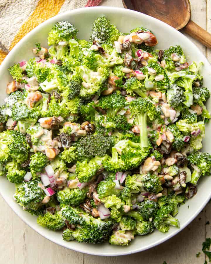 Bowl of Vegan Broccoli Salad with napkin and spoon on the side.