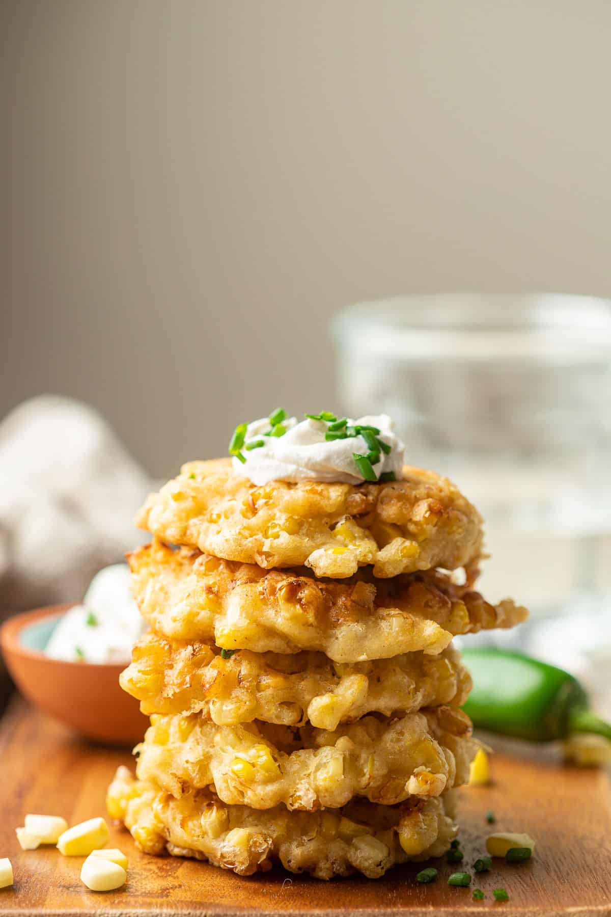 Stack of Vegan Corn Fritters with vegan sour cream on top.