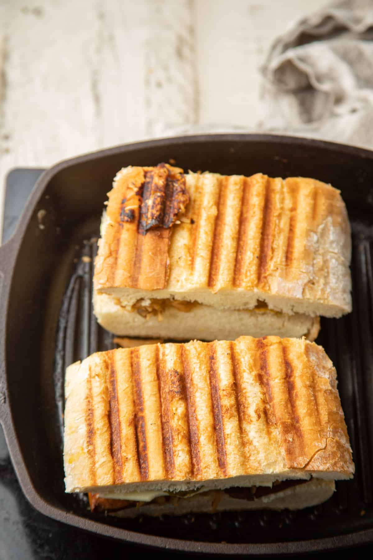 Two Vegan Cuban Sandwiches cooking in a grill pan.