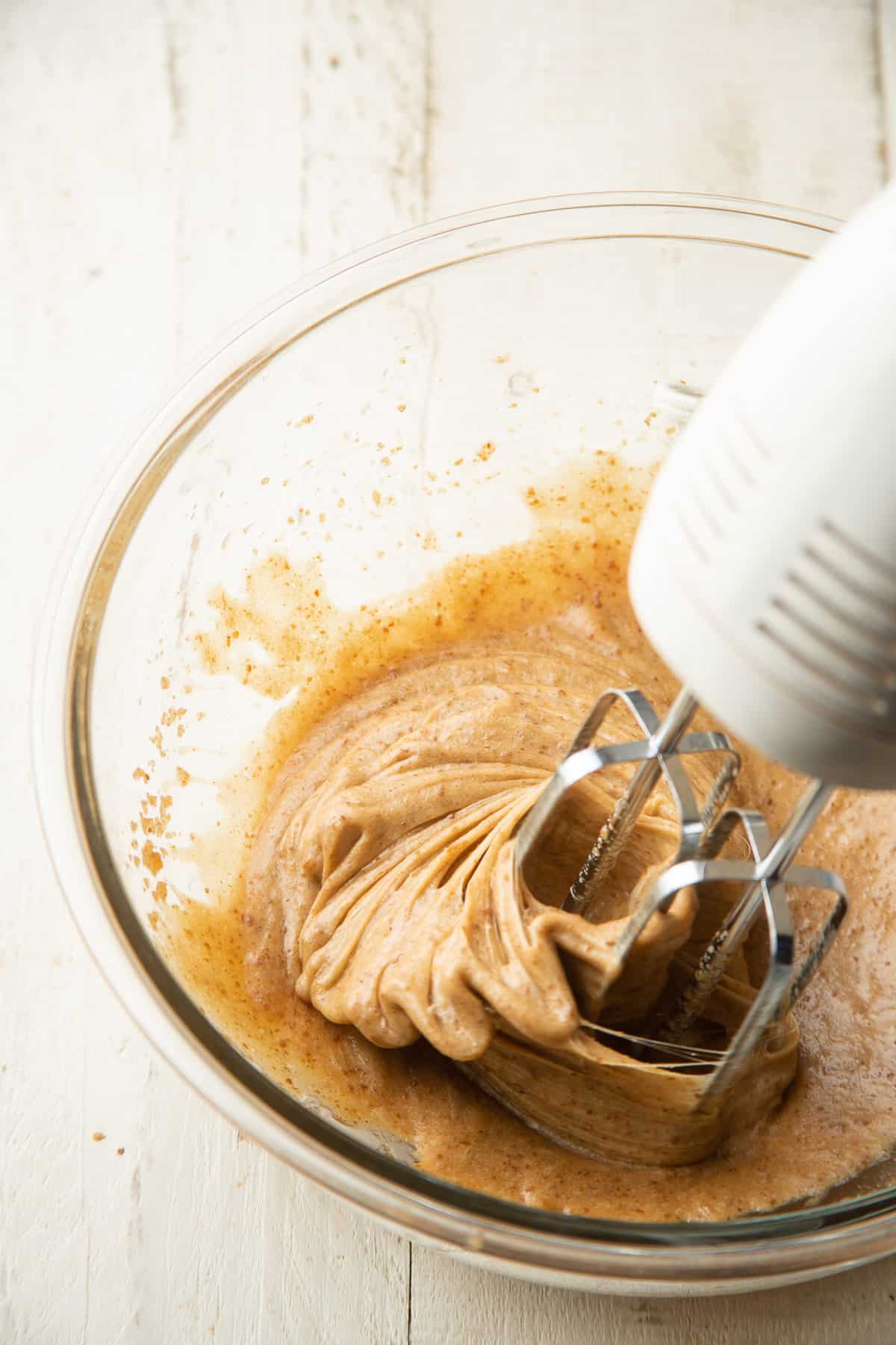 Electric mixer beating flax egg into vegan butter and brown sugar.