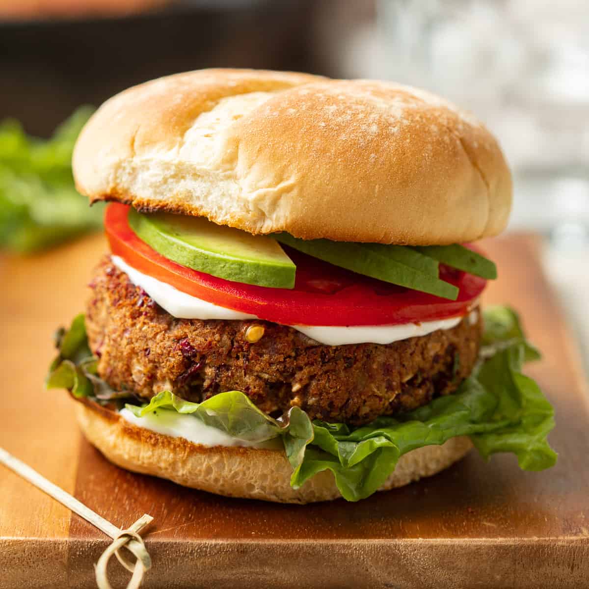 Kidney Bean Burger on a wooden surface with a skewer on the side.