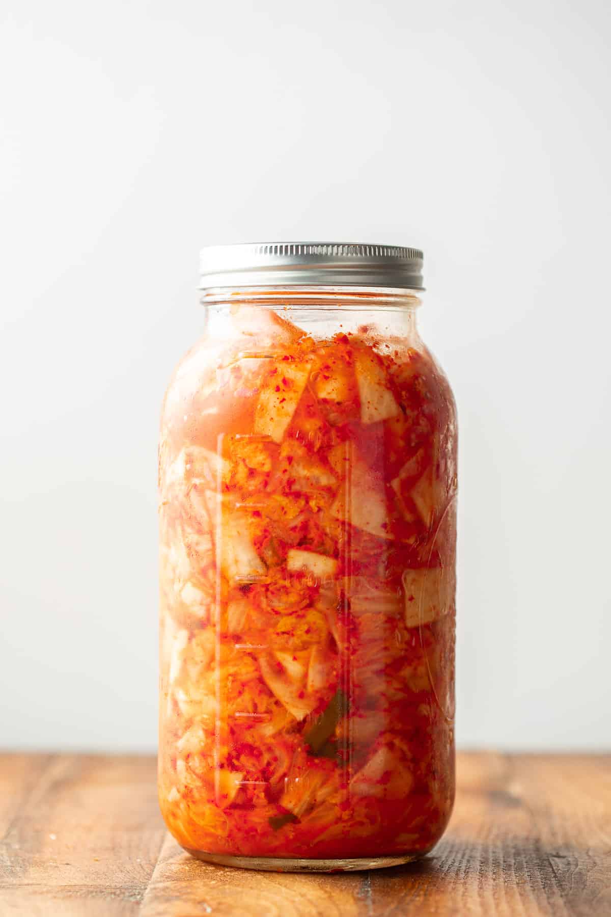 Jar of Vegan Kimchi in front of a white background.