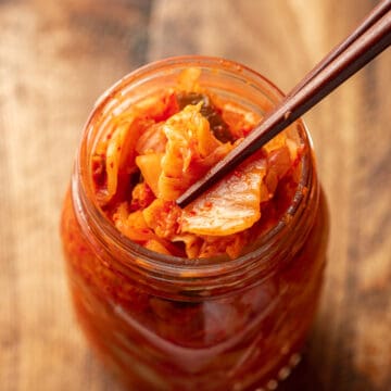 Chopsticks taking Vegan Kimchi from a jar.