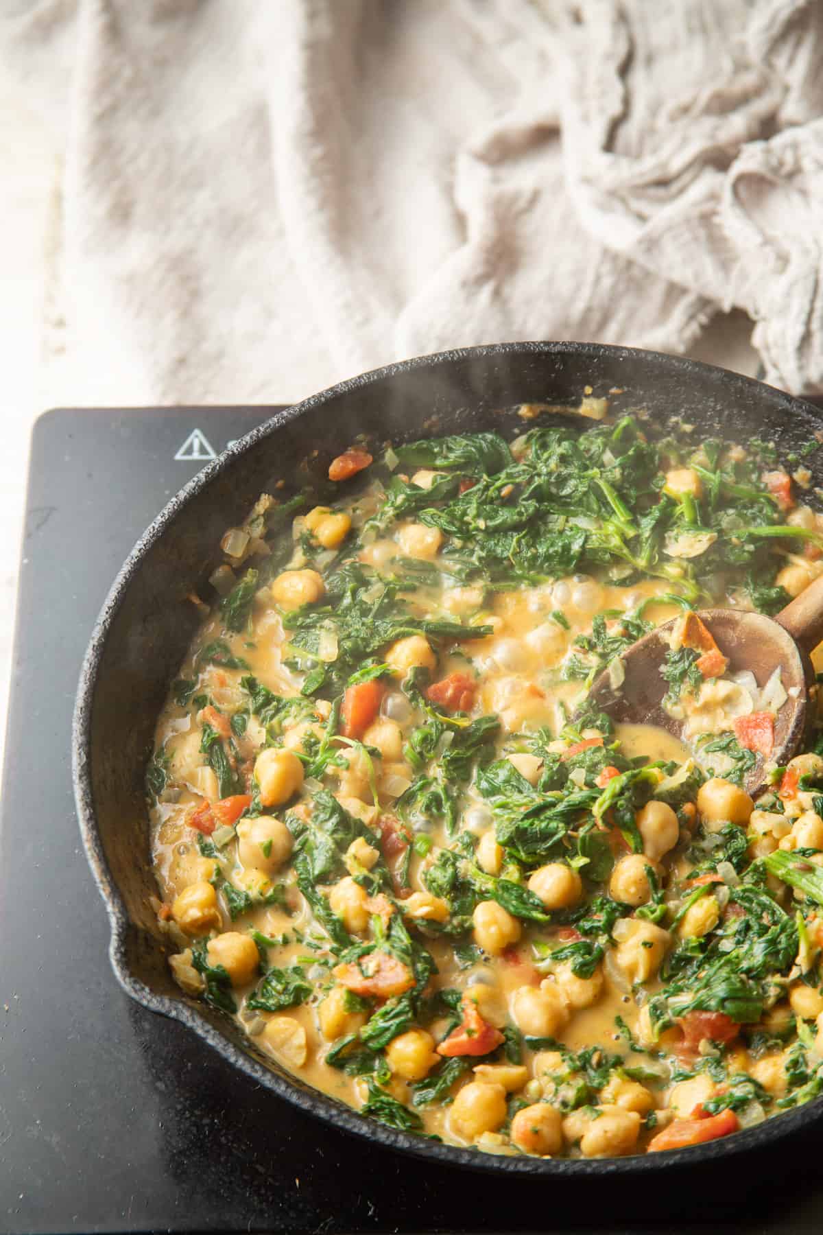 Chickpea & Spinach Curry simmering in a skillet.