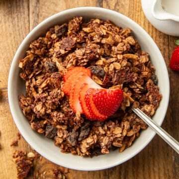Bowl of Chocolate Granola with a sliced strawberry on top.