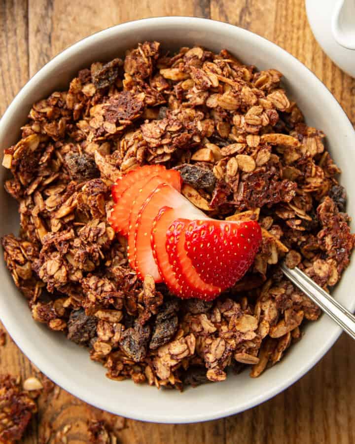 Bowl of Chocolate Granola with a sliced strawberry on top.