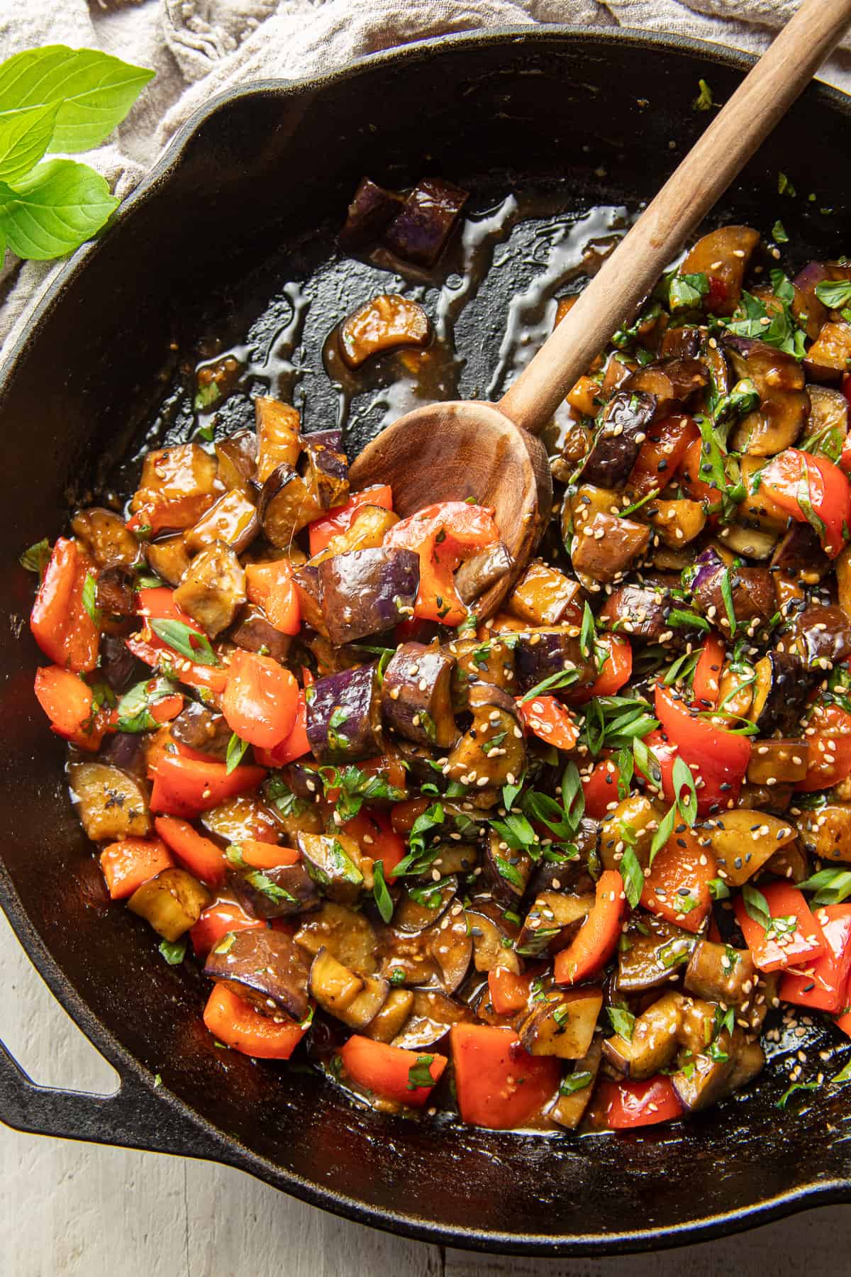 Eggplant Stir Fry in a skillet with wooden spoon.
