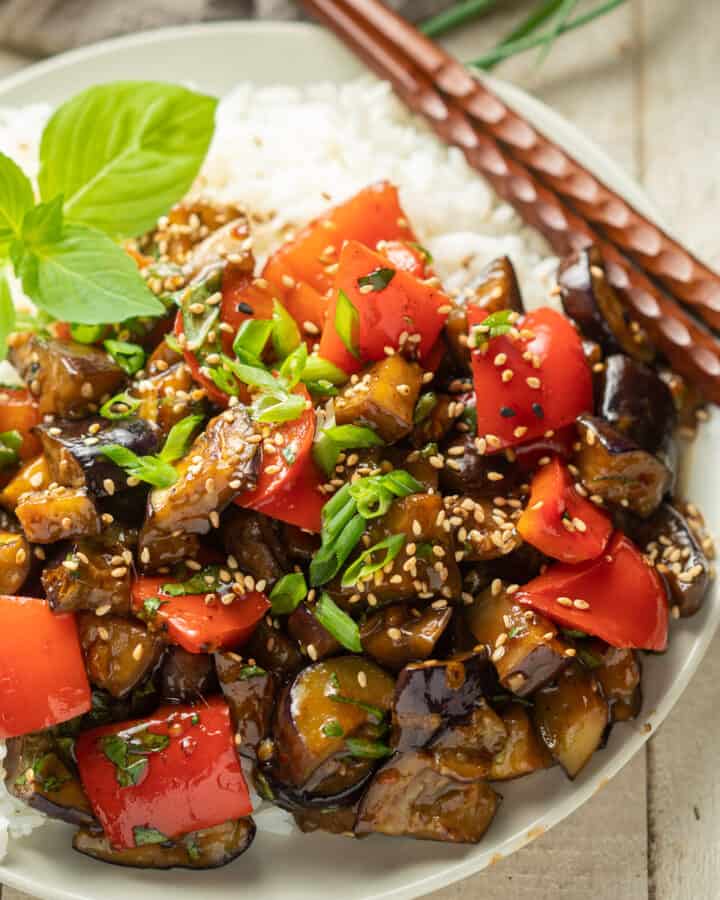 Eggplant Stir Fry on a plate with rice and chopsticks.