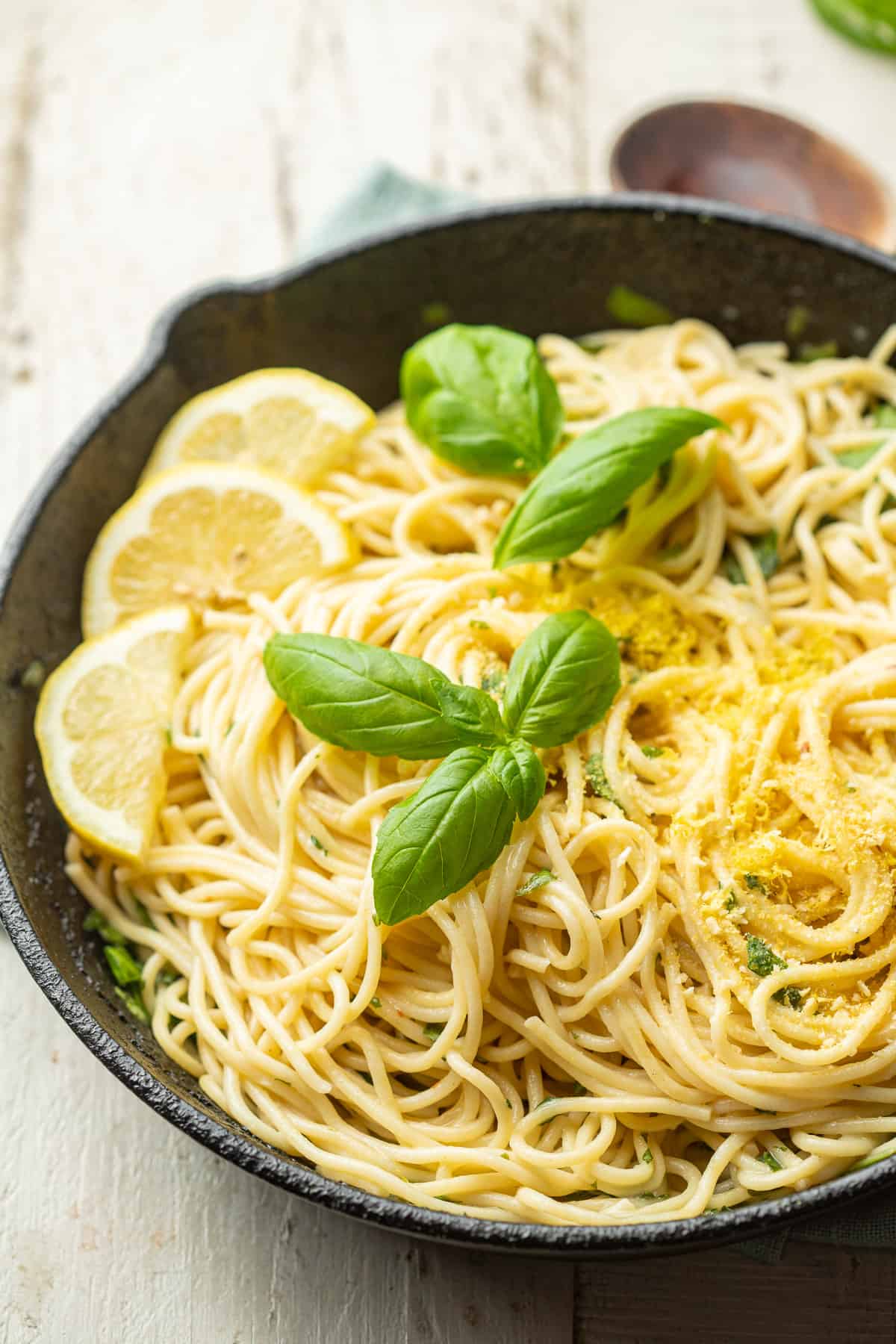 Skillet of Lemon Pasta with wooden spoon in the background.
