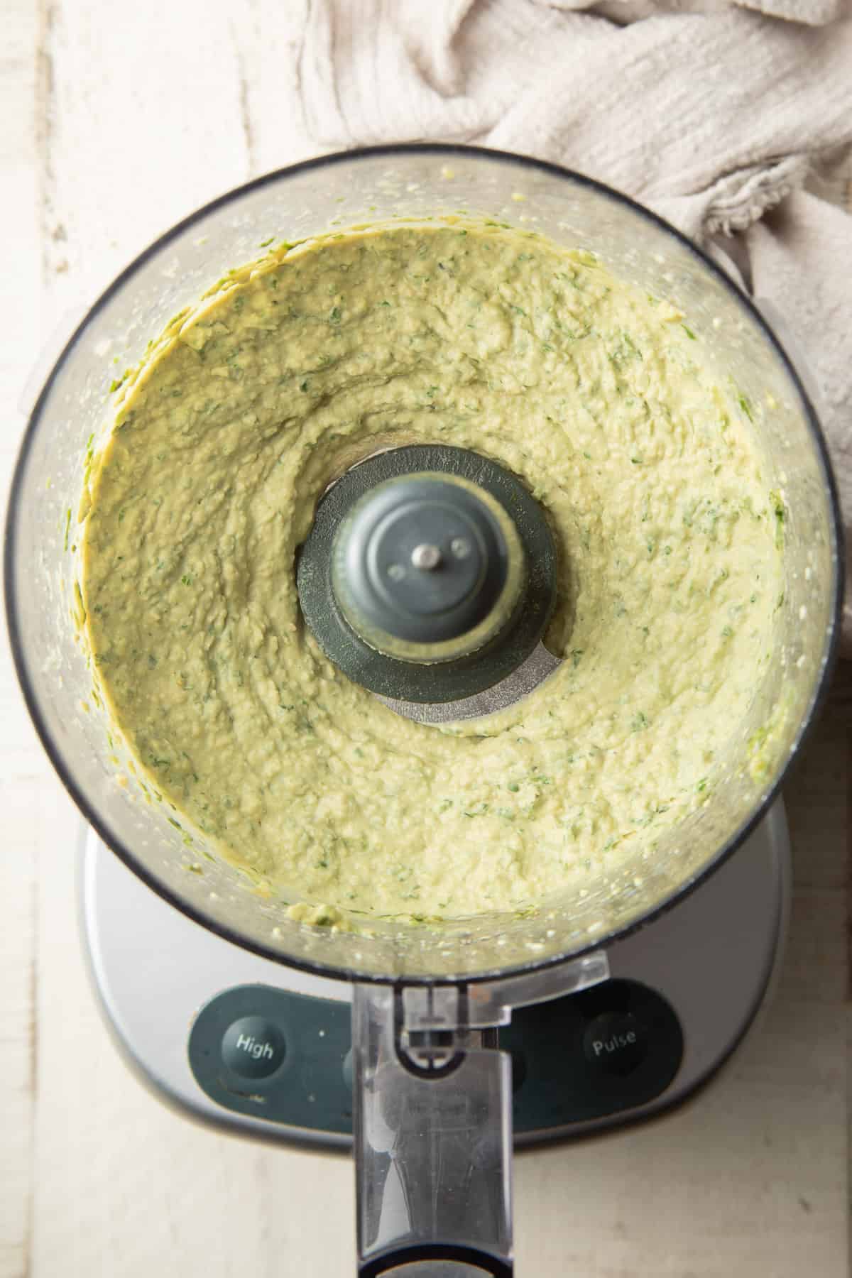 Pesto Hummus in a food processor bowl just after blending.