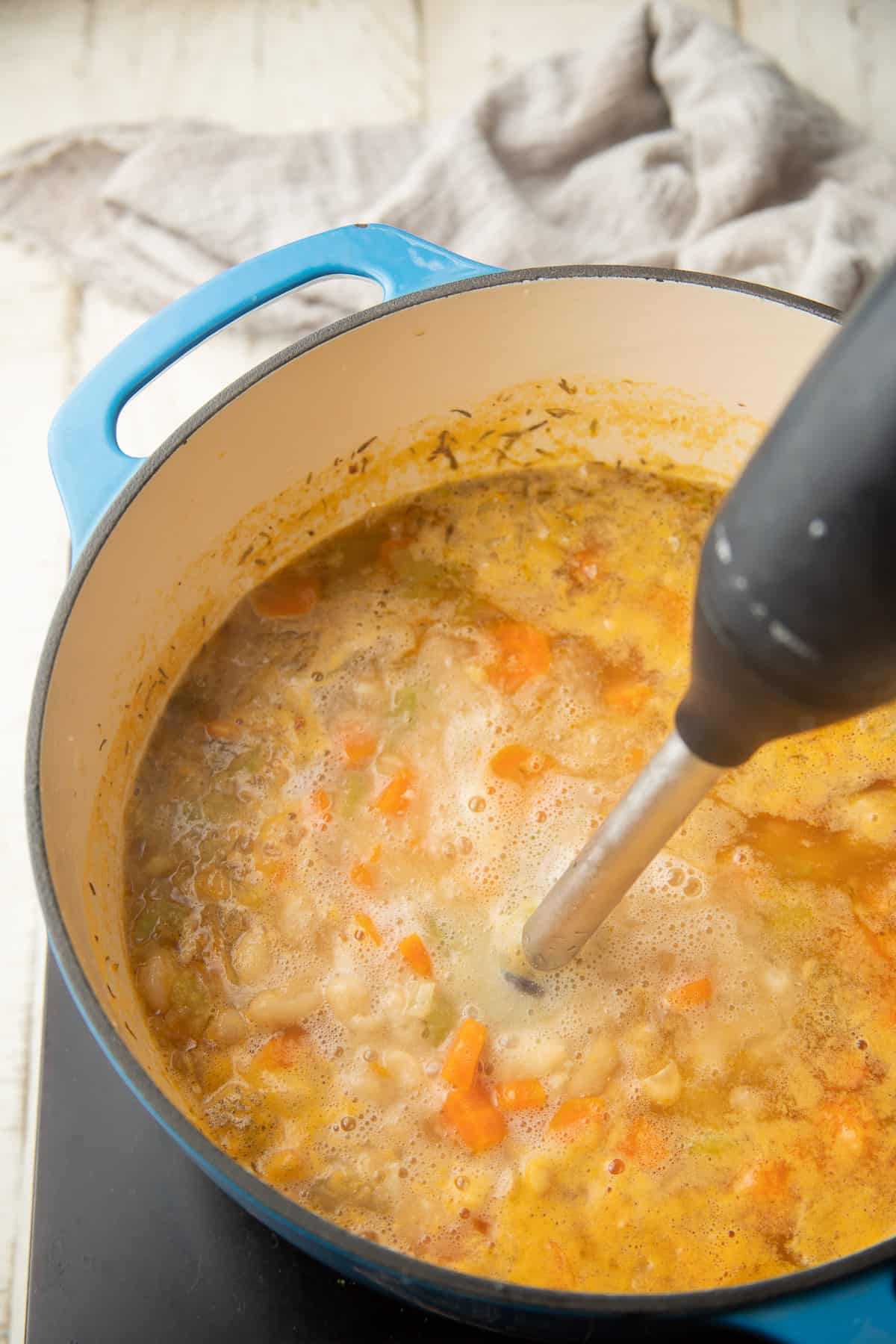 Immersion blender blending a pot of soup.