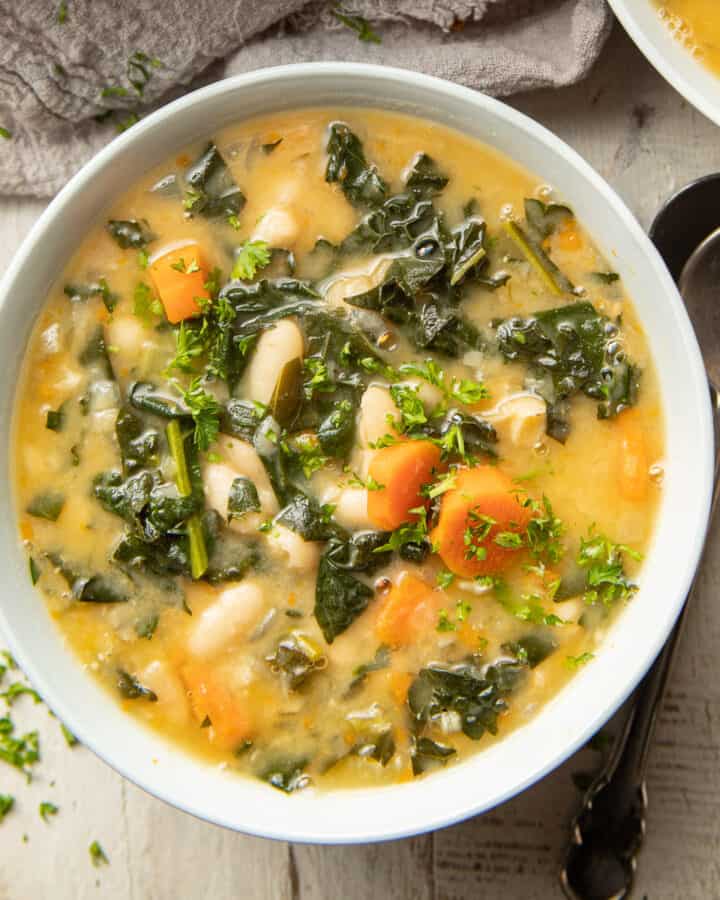 Bowl of Tuscan Kale Soup with two spoons on the side.