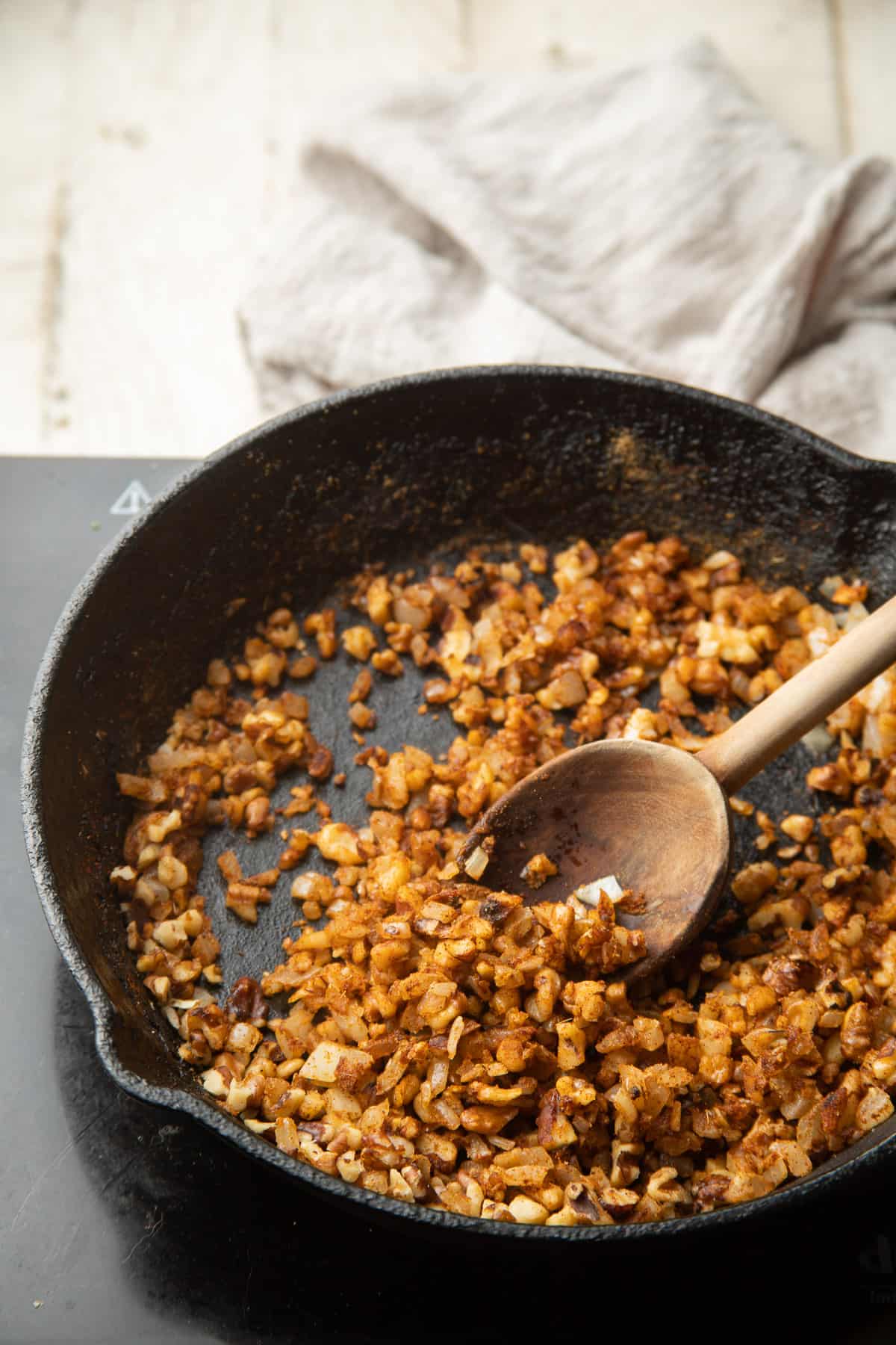 Onions, garlic, spices and walnuts cooking in a skillet.