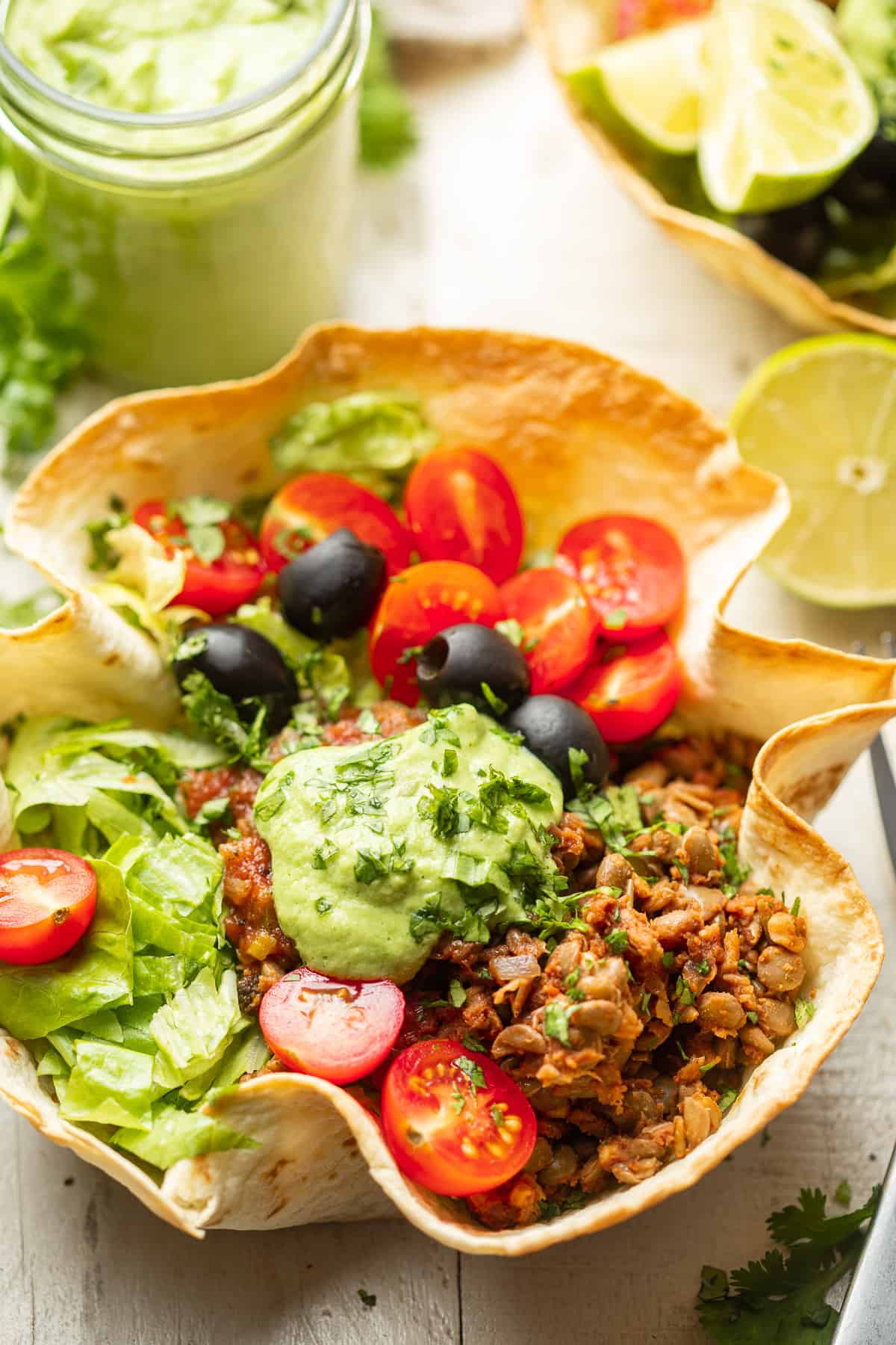 Gros plan d'une salade de tacos végétaliens avec remplissage de noix de lentilles dans un bol de tortilla.