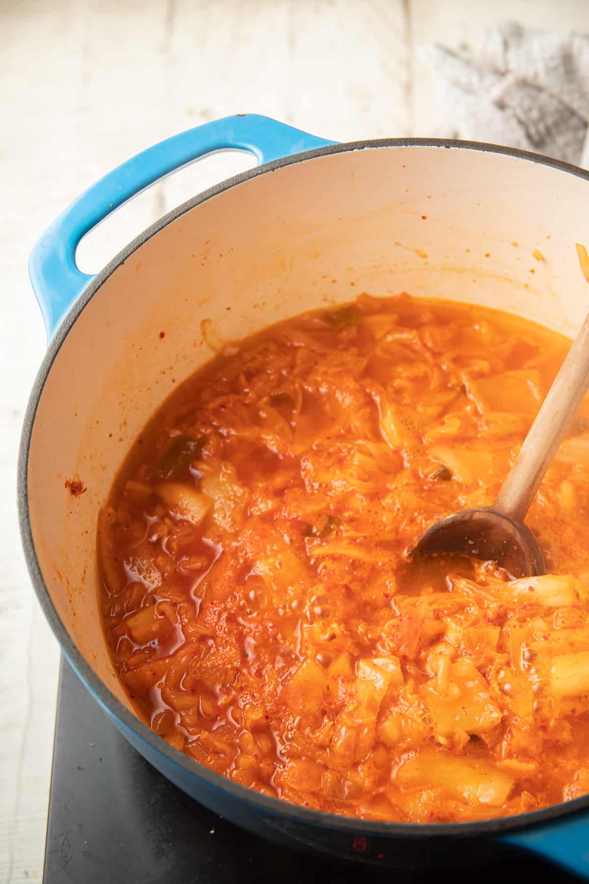 Kimchi simmering in broth in a pot.