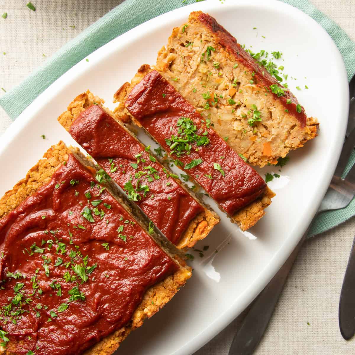 Partially sliced Vegan Meatloaf on an oval serving dish.