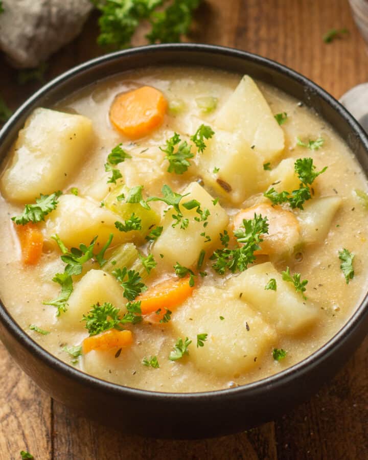 Bowl of Vegan Potato Soup topped with fresh parsley.